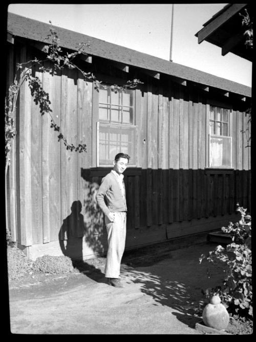 Young man in front of wooden building