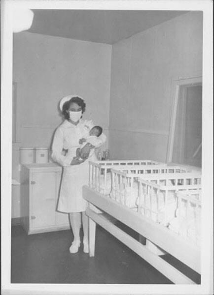 [Nurse carrying newborn infant, Rohwer, Arkansas]