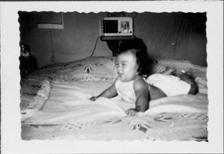 [Smiling infant lying on bedspread, Rohwer, Arkansas, July 29, 1944]