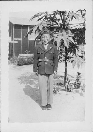 [Boy in Army uniform next to tree, Rohwer, Arkansas, August 6, 1944]