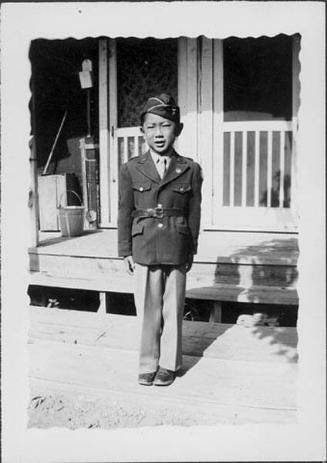 [Boy in Army uniform in front of barracks, Rohwer, Arkansas, August 6, 1944]