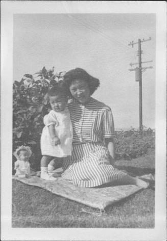 [Toddler and woman on blanket on grass, Rohwer, Arkansas, September 3, 1944]