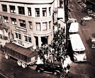 [Aerial perspective of crowd boarding buses in front of Nishi Hongwanji Buddhist Temple, Los Angeles, California, 1942]
