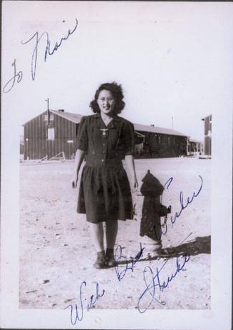 [A young woman, Itsuko, standing next to a fire hydrant, Heart Mountain, Wyoming, 1943]