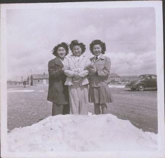 [Three girls standing in snow, Heart Mountain, Wyoming, 1943]