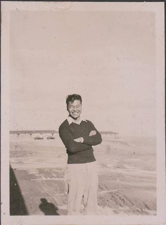 [Young man standing with arms crossed, Heart Mountain, Wyoming, 1944-1945]