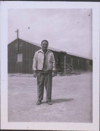 [Portrait of Man standing in front of barracks, Heart Mountain, Wyoming, 1945]