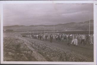 [Large crowd of people walking up road, Heart Mountain, Wyoming, 1945]