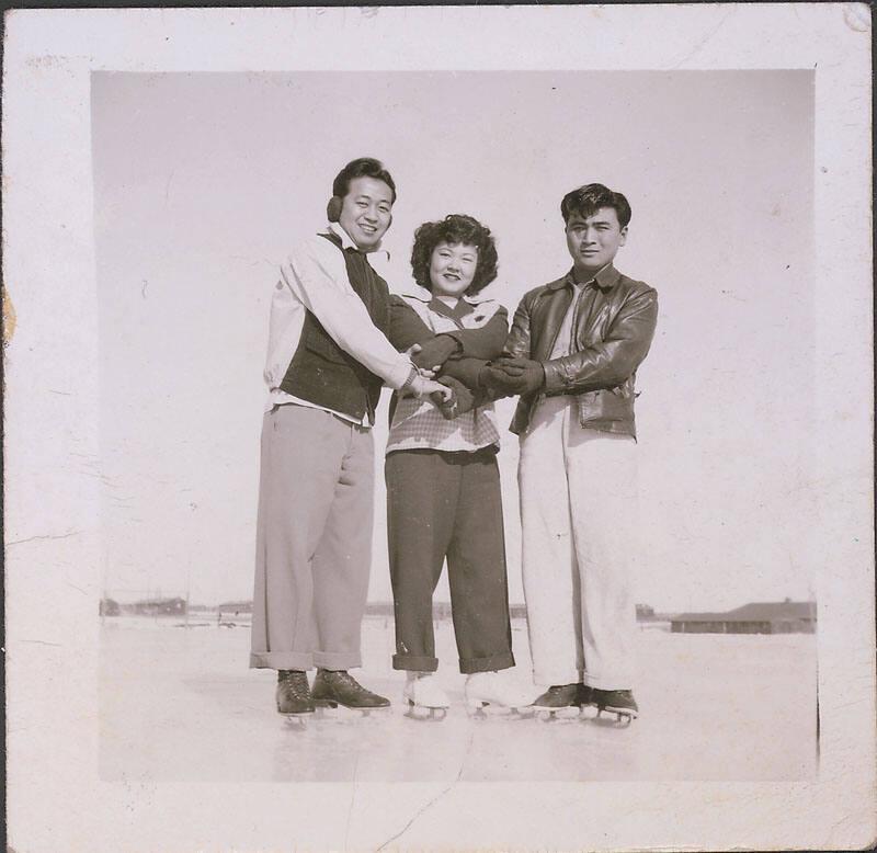 [Two young men and one young woman in ice skates holding hands, Heart Mountain, Wyoming, 1942-1945]