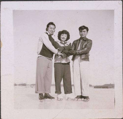 [Two young men and one young woman in ice skates holding hands, Heart Mountain, Wyoming, 1942-1945]