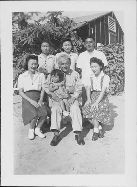 [United States Army soldier holding little girl amidst five people, Rohwer, Arkansas, August 20, 1944]