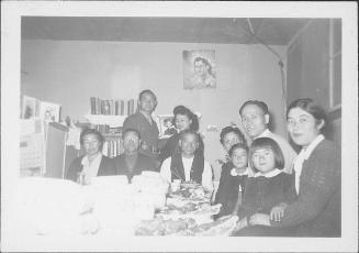 [Soldier and family around table covered with food, Rohwer, Arkansas, December 19, 1944]