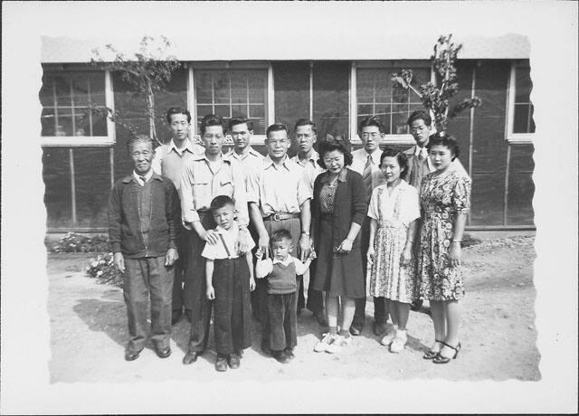 [Group portrait of eleven adults and two boys in front of barracks, Rohwer, Arkansas]