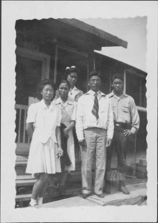 [Three women and two men standing on barracks porch steps, Rohwer, Arkansas]