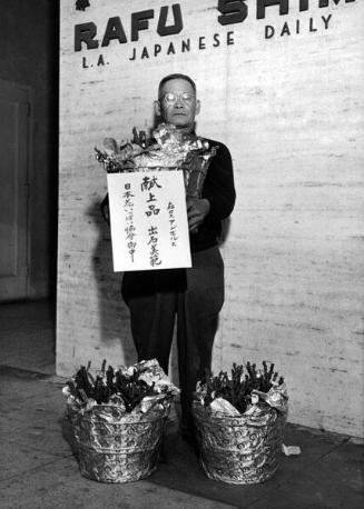 [Mr. Yoshinori Ideishi holding rose plants sent to Emperor and Empress of Japan, February 1956]