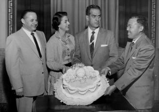 [George Izumi of Grace Pastry Shoppe presents cake at Los Angeles City Hall in appreciation of Council resolution declaring April 29th to May 4th "American Bakers" week, Los Angeles, California, March 28, 1957]