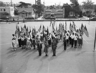 [Girl and Boy scouts holding American flags in Hobart Boulevard School yard, Los Angeles, California, May 2, 1957]