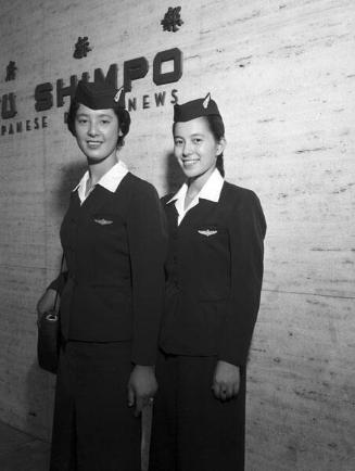 [Two airline stewardesses in front of Rafu Shimpo, Los Angeles, California, 1957]