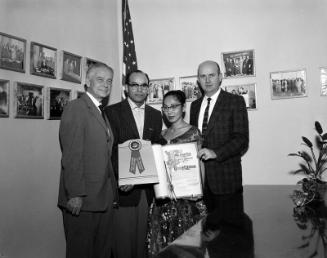[George F. Robinson of Modern Shoe Repair receives special Los Angeles City Council resolution in the office of councilman Gordon Hahn, Los Angeles City Hall, Los Angeles, California, December 19, 1957]