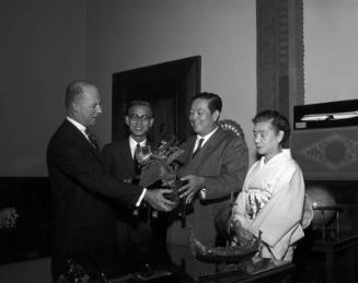 [Shuji Kawasaki, Japanese Diet member of Nagoya, presenting Japanese Samurai helmet to Los Angeles City at Mayor's office in City Hall, Los Angeles, California, August 26, 1959]