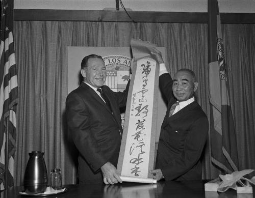 [Sekke Ogomori presents calligraphy scroll to Los Angeles Mayor Sam Yorty at Los Angeles City Hall, Los Angeles, California, August 1963]