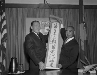 [Sekke Ogomori presents calligraphy scroll to Los Angeles Mayor Sam Yorty at Los Angeles City Hall, Los Angeles, California, August 1963]