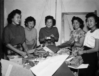 [Girl's Club wrapping toys for Christmas Cheer Project at Crossroads office, December 12, 1950]