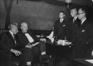 [Two seated Caucasian men and three standing Japanese men, California, 1964]