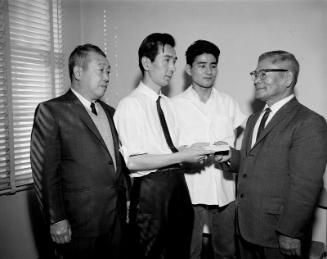 [Nichoren giving money for Pasadena Buddhist Church cooking exhibition at Japanese Chamber of Commerce office, Los Angeles, California, January 17, 1966]