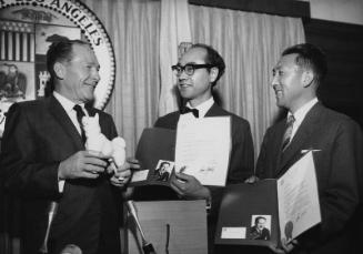 [Los Angeles Mayor Sam Yorty exchanges gifts with two men at Los Angeles City Hall, Los Angeles, California, 1966?]