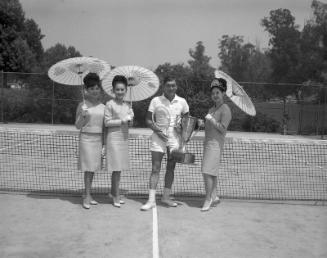 [Tennis player with trophy and Nisei Week Queen and court, California, 1966?]