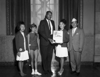 [Los Angeles City Councilman Thomas Bradley presenting City Council resolution to the National Baton Twirling Association, Los Angeles, California, August 21, 1967]