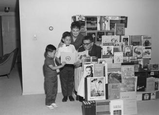 [Taro Yashima and Mrs. Evelyn Charnoff with children's literature book display for National Children's Book Week and American Education Week, California, November 16, 1968]