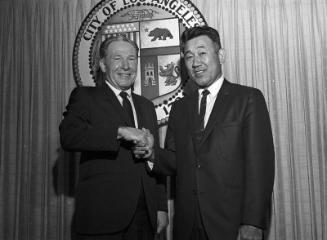 [Los Angeles Mayor Sam Yorty congratulating Tosh Terazawa, newly appointed President of Building Safety Commissioners, at Los Angeles City Hall, Los Angeles, California, August 21, 1969]