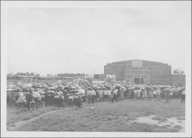 [Funeral gathering outside of large building with American flag, Rohwer, Arkansas, September 30, 1944.