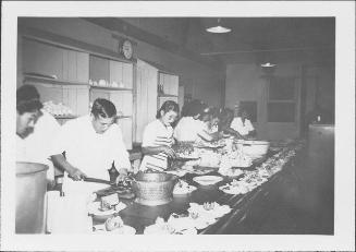 [Men and women preparing plates of food in mess hall, Rohwer, Arkansas, 1942-1945]