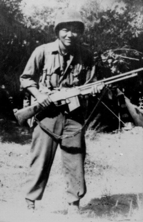 [Sadao S. Munemori in uniform with a rifle]