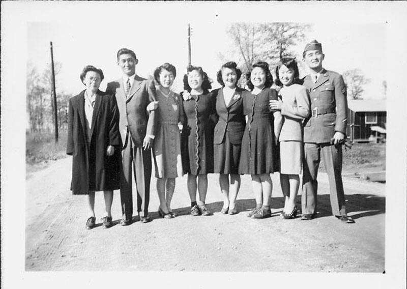 [United States Army corporal standing with group on dirt road, Rohwer, Arkansas, May 15, 1945]