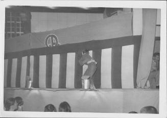 [Man walking in front of striped curtain in Kabuki play, Rohwer, Arkansas]