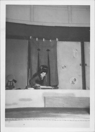 [Young woman leaning over desk in Kabuki play, Rohwer, Arkansas, October 21, 1944]