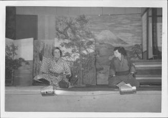 [Two men sitting and talking in Kabuki play, Rohwer, Arkansas]