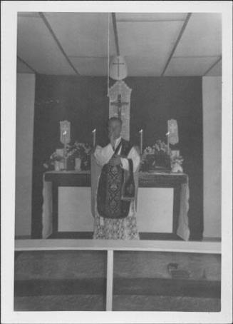 [Catholic priest in front of altar, Rohwer, Arkansas, November 1, 1944]